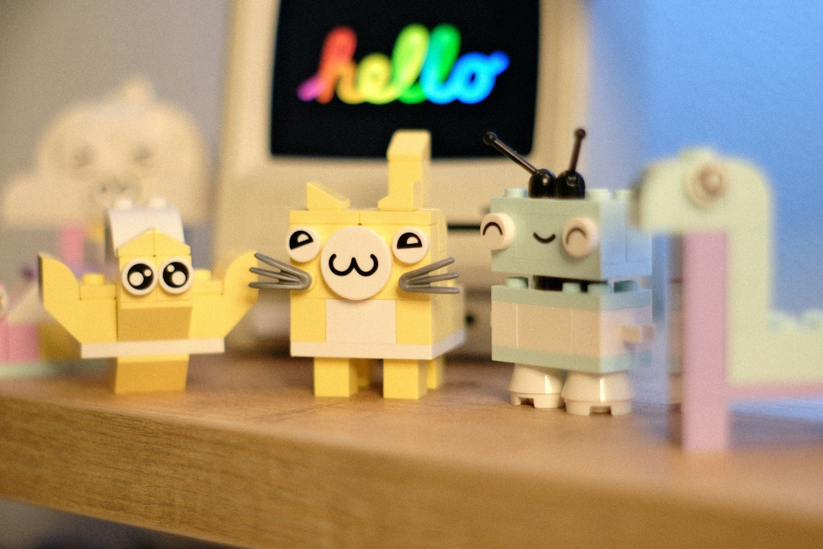 Three cute lego figures stand on a shelf with